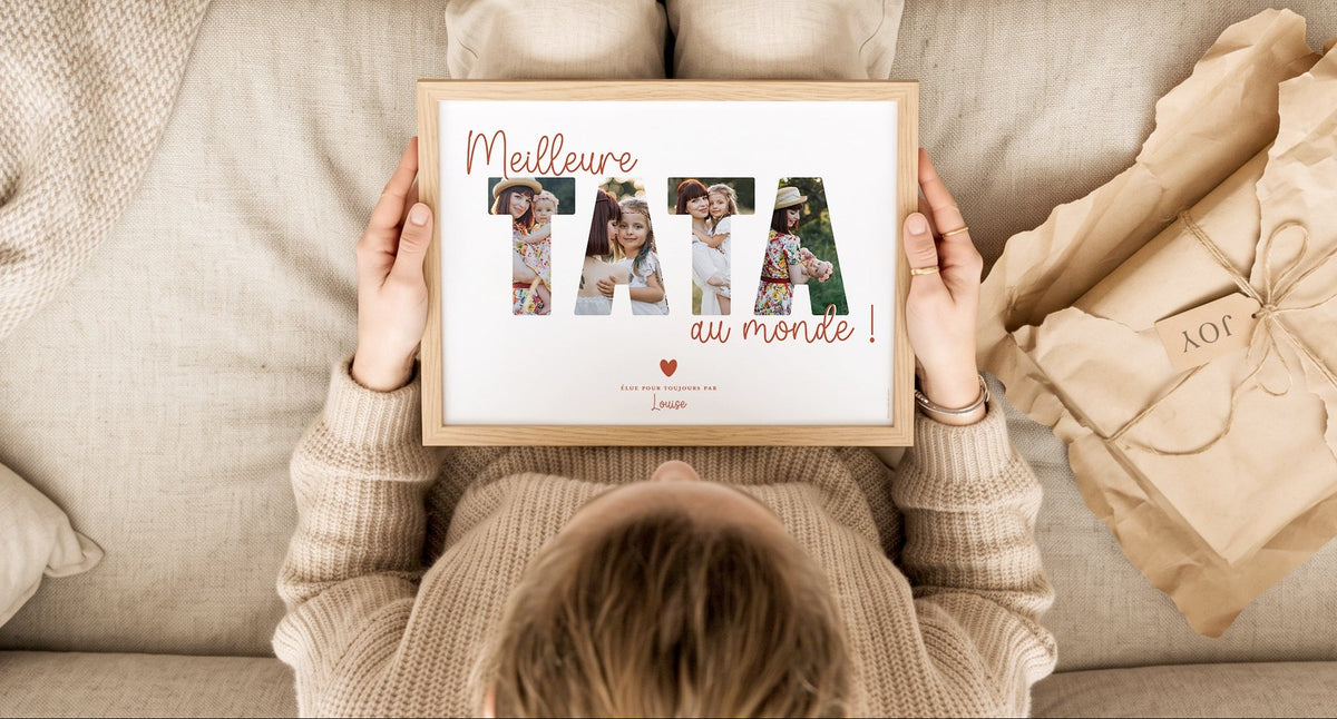Vue du dessus d'une personne tenant un cadre en bois personnalisé avec le texte 'Meilleure TATA au monde' et des photos de famille.